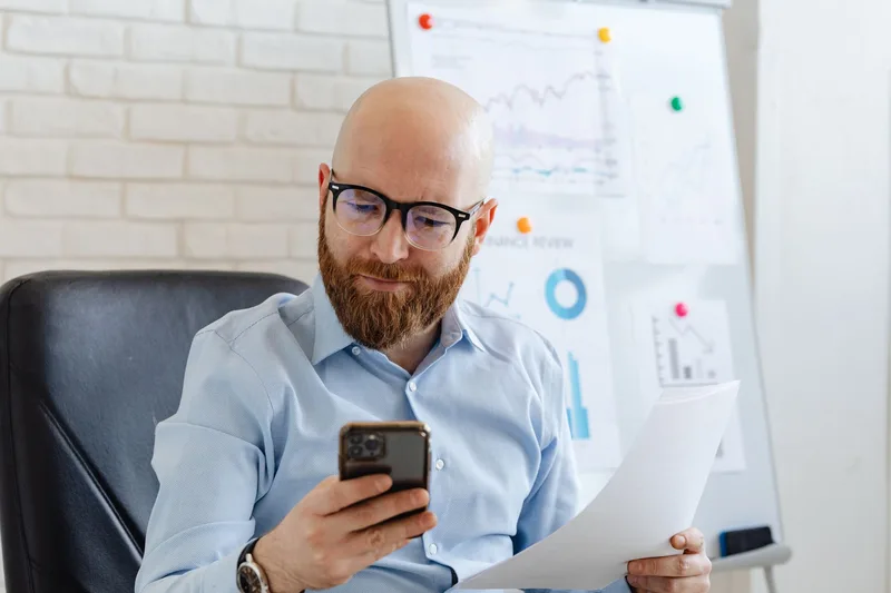 Business owner reviewing campaign results on smartphone showing customer engagement data