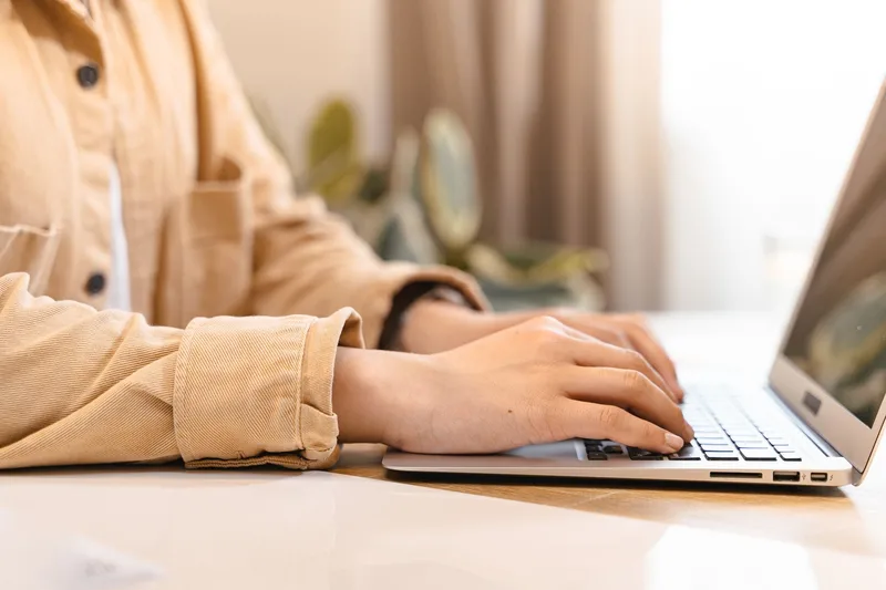 A business owner types on a laptop at their desk