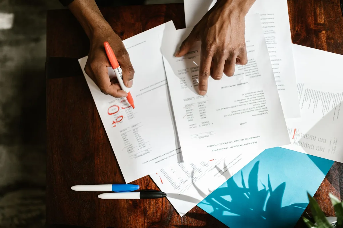 A business owner reviews financial paperwork spread across a desk