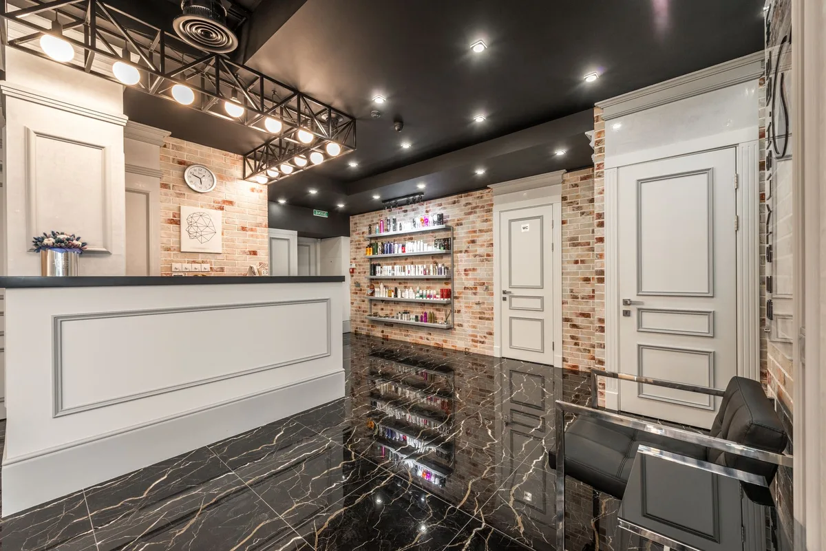 Kaunter hadapan salon kecantikan dengan rak produk tersusun di sebelah