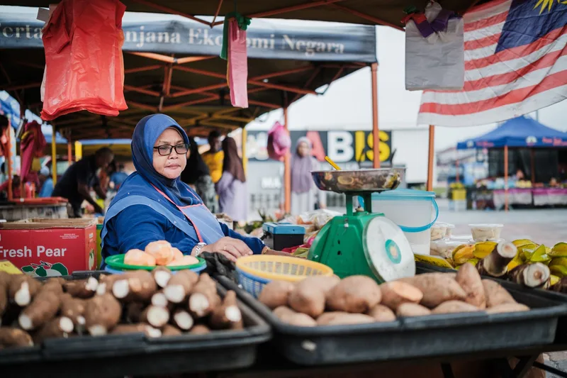 A Malaysian florist business owner opening her shop for customers, representing local service businesses