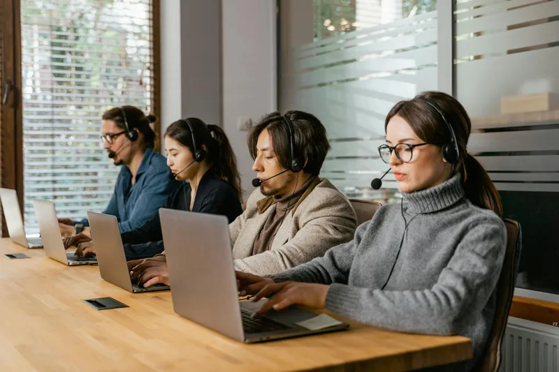 A team working together at computers in a call centre, representing shared inbox management