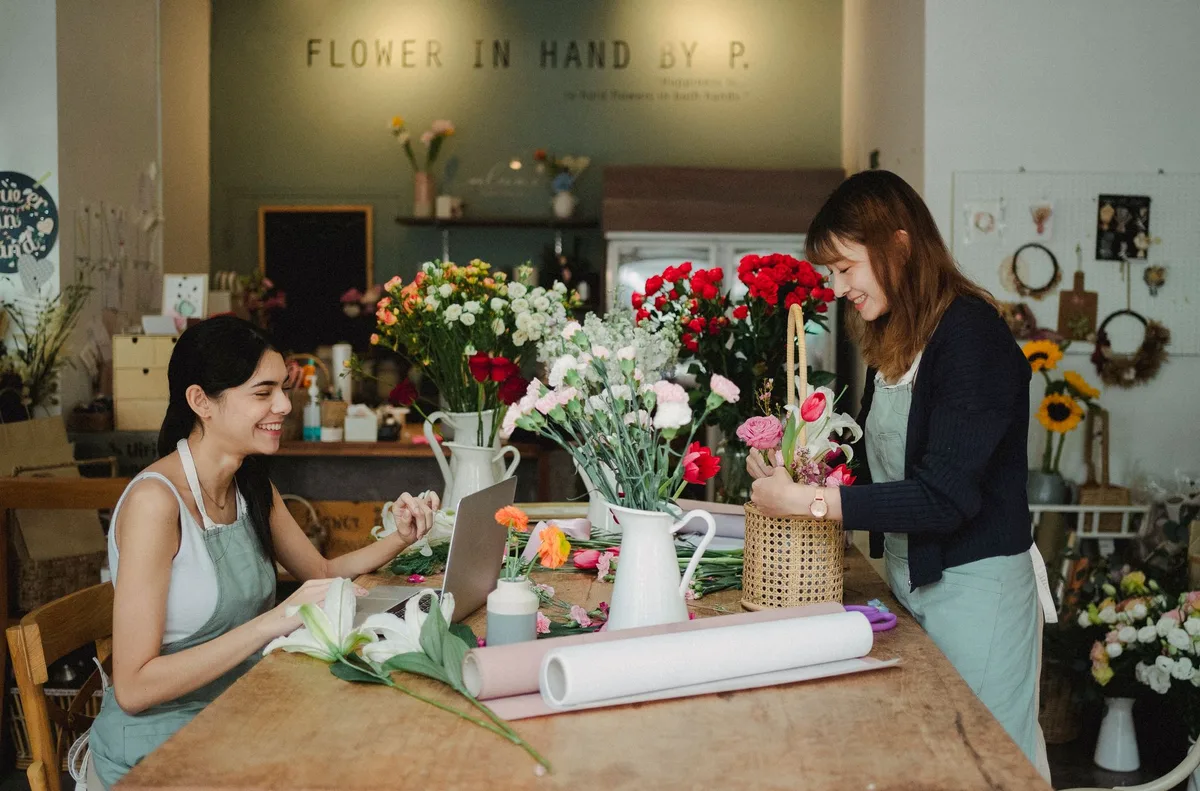 A small business owner works at a laptop inside her shop