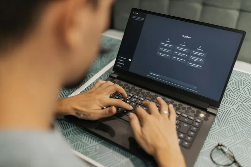 A business owner sits at a laptop reviewing a clean dashboard showing WhatsApp conversation metrics and AI response rates