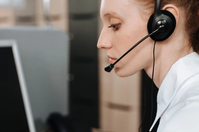 Close-up of a call center agent wearing a headset at her desk