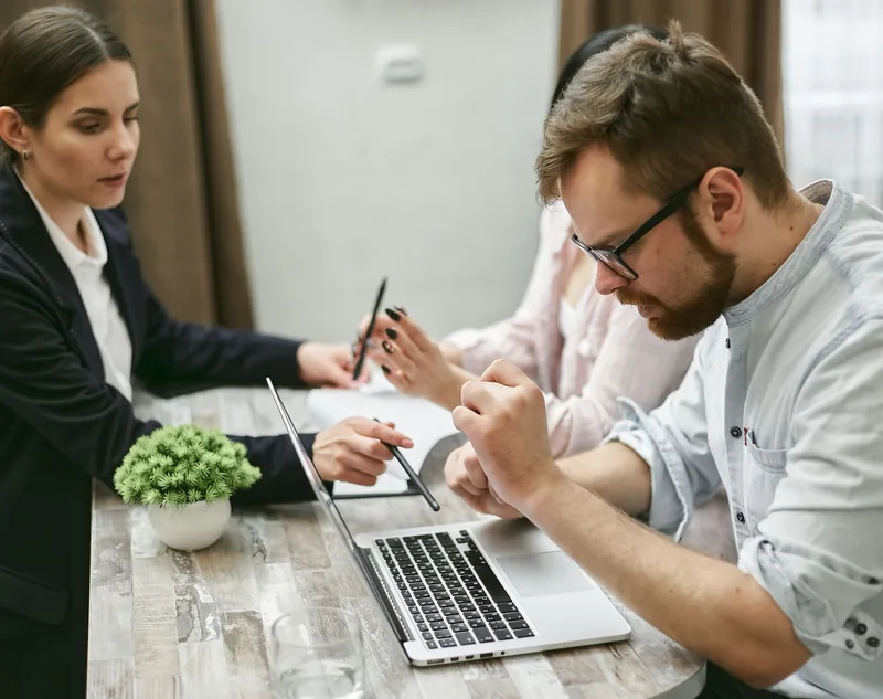 Businesswoman checking customer messages on laptop and mobile phone