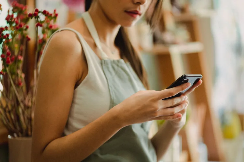 Business owner reviewing customer engagement on smartphone